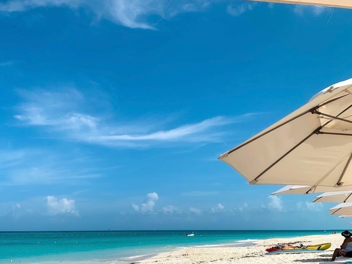 a blue umbrella sitting on top of a sandy beach