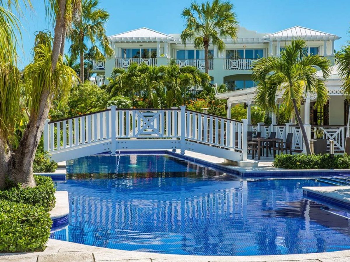 a pool next to a palm tree in front of a building